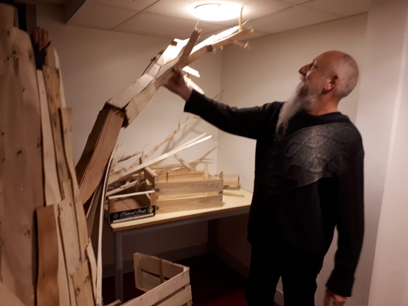 Le professeur d'arts plastiques, Thierry Delétraz, qui monte une œuvre à base de bois de palettes